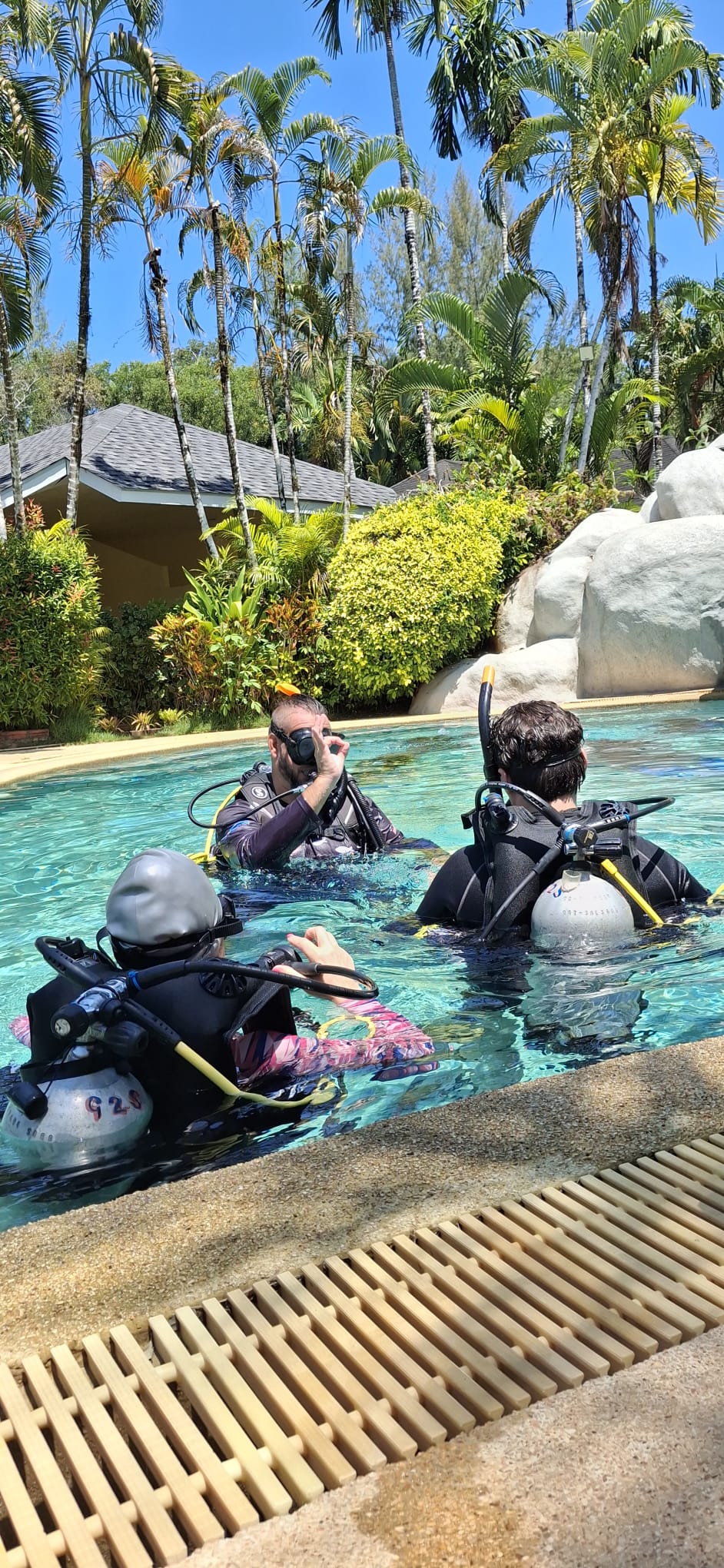 PADI IDC candidates receiving a confined-water briefing in the pool